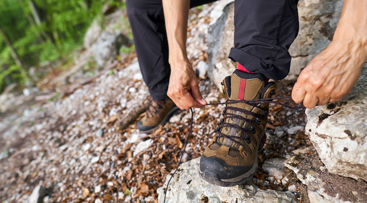 man lacing hiking boot