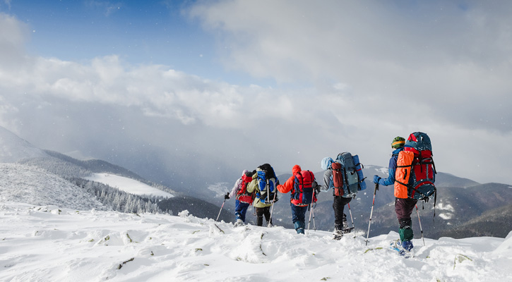 people hiking on snowy mountain