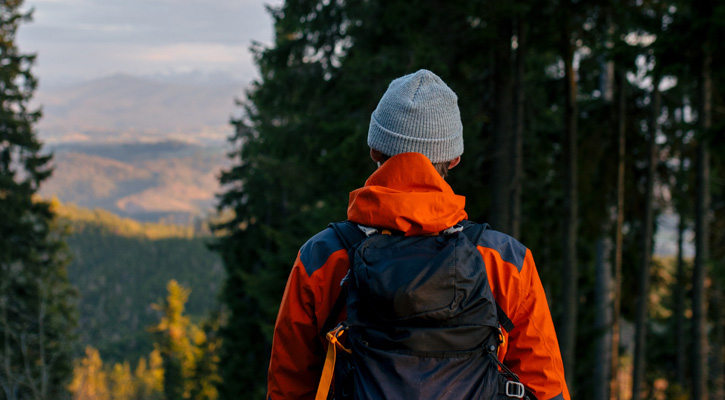 hiker wearing jacket and backpack in the mountains