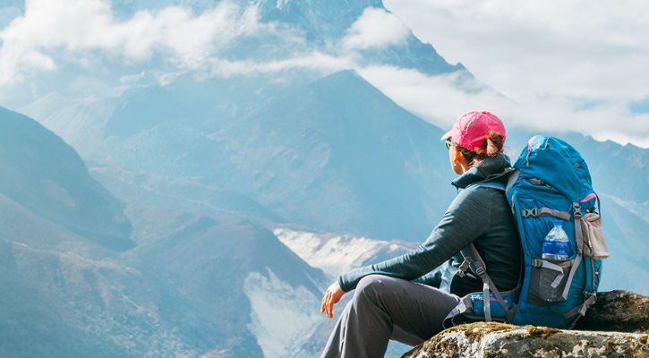 hiker with backpack on top of a mountain