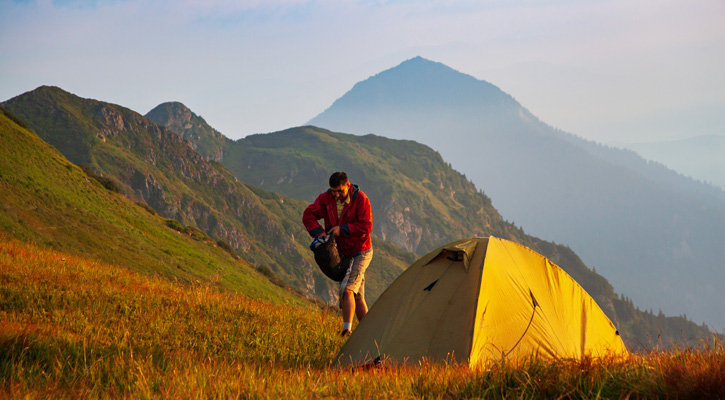 hiker with tent in the mountains