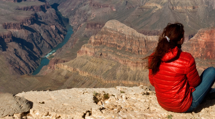 woman wearing a down jacket on top of a mountain