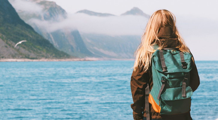 woman with blue backpack at the lake