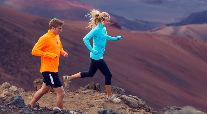 young couple running on a mountain trail