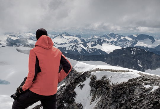 hiker wearing hardshell jacket on a snowy mountain