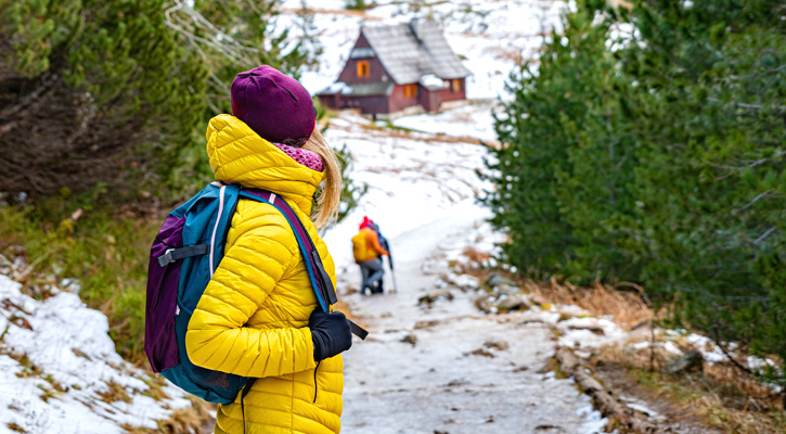 woman wearing high-end hiking clothes on a snowy mountain trail